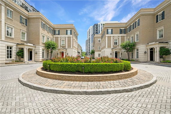 Front view of multiple three-story townhouses with brick exteriors and classic architectural details.