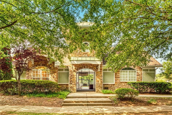 Front view of a building with stone facade and arched entryway.