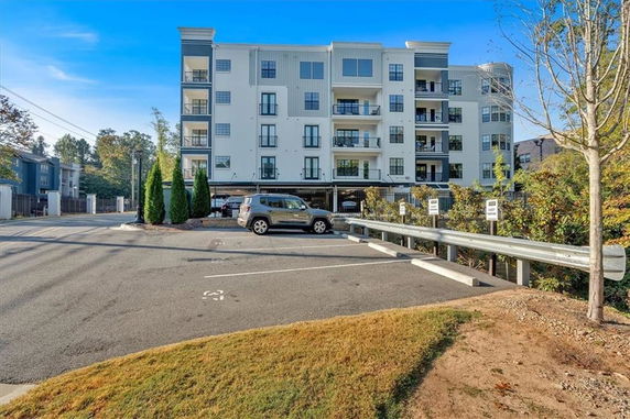 Outdoor parking area in front of a multi-story building.