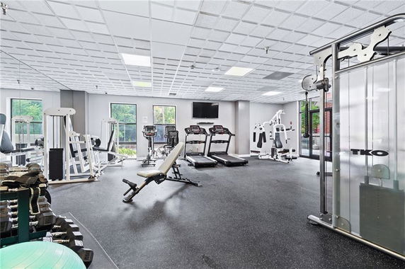 Indoor gym area with various exercise equipment and machines.