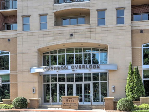 Front view of a contemporary building with large windows and a central entrance labeled 'EMERSON OVERLOOK'.