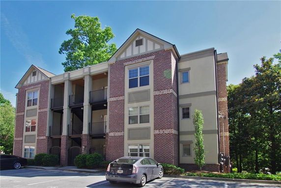 Front view of a multi-story apartment building with a brick and stucco facade.