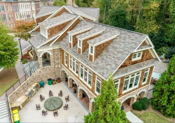 Elevated view of a large two-story building with a complex roof design and multiple windows.