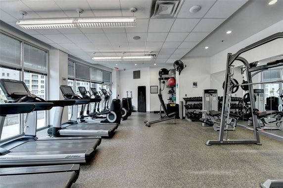 Interior view of a gym with treadmills, weights, and exercise equipment.