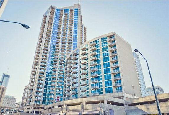 Front view of a modern high-rise building with multiple balconies and large windows.