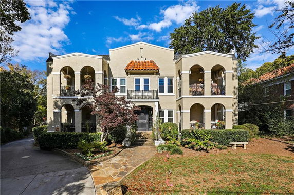 Front view of a two-story house with balconies and arches.