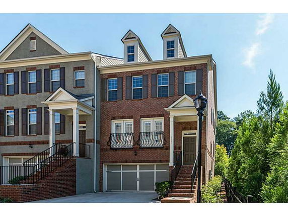 Front view of a three-story townhouse with brick facade and garage.