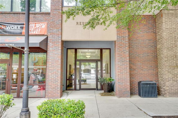 Front view of a brick building entrance with glass door.