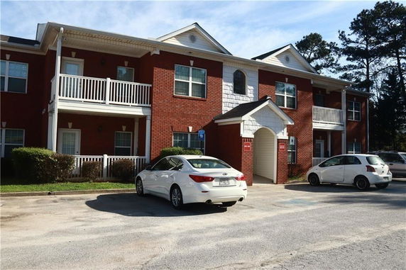 Front view of a two-story red brick building with balconies.