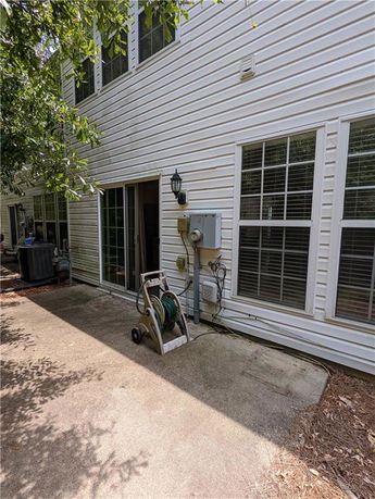 Exterior view of a two-story house with white siding and multiple windows.
