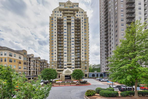 Front view of a high-rise residential building with multiple balconies.