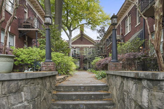 Front view of a brick apartment building with balconies and decorative columns.