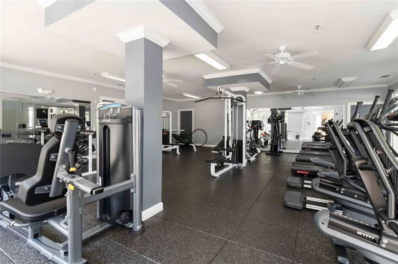 Interior view of a gym with exercise equipment and machines.