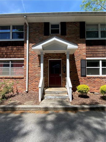 Front view of a two-story brick building with a small entrance canopy.