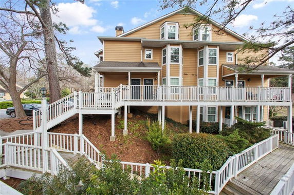 Front view of a multi-story house with a wrap-around porch and multiple balconies.
