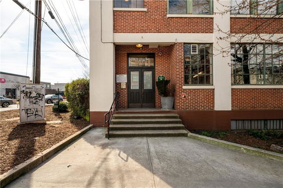 Front view of a brick building entrance with steps leading up.