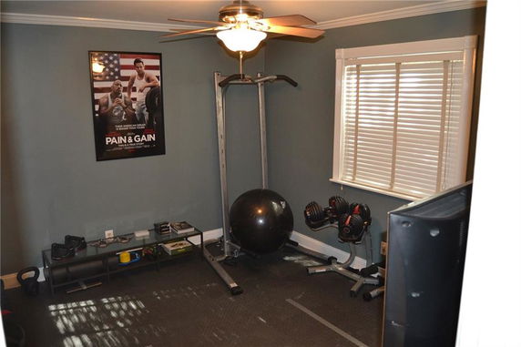 Room equipped with gym equipment including a stability ball, adjustable dumbbells, and a pull-up bar.