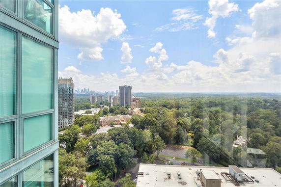 Panoramic view from a high-rise building showing a cityscape with buildings surrounded by greenery.