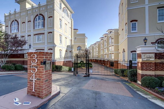 Front view of a multi-story building complex with gated entrance.
