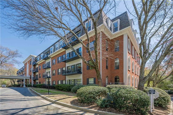 Front view of a multi-story brick apartment building with balconies.