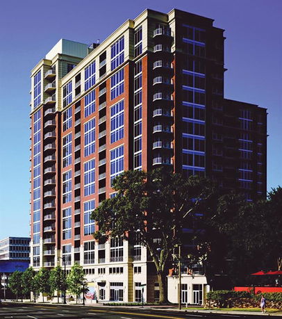 Front view of a multi-story building with large windows and a brick facade.