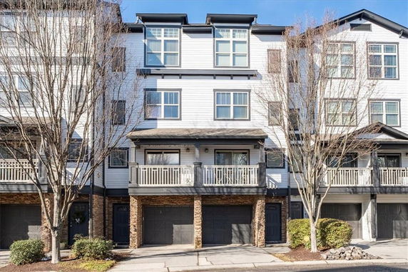 Front view of a multi-story townhouse with a double garage.