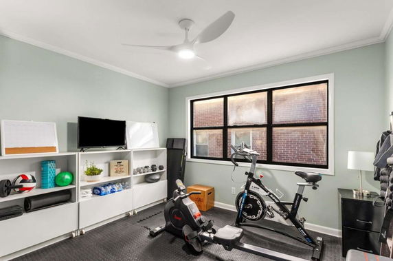 Indoor room with exercise equipment and shelving.