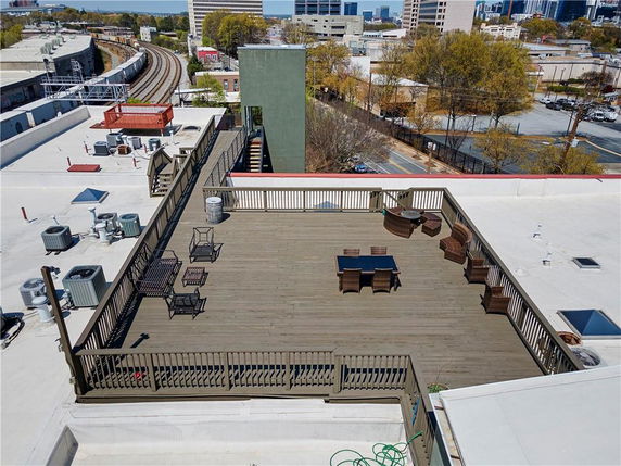 Rooftop with seating area and surrounding urban view.