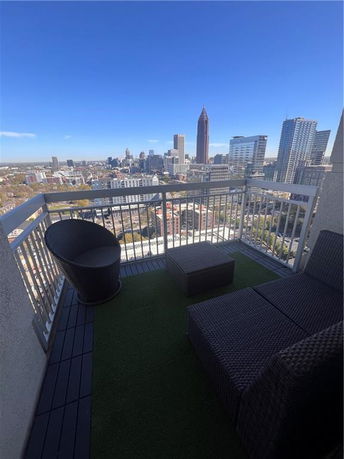 Panoramic view from a balcony overlooking a city skyline.