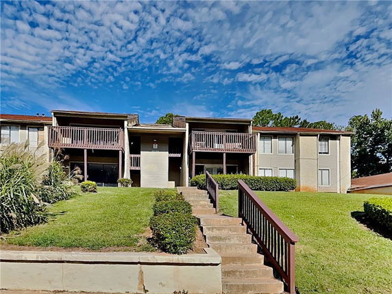 Front view of a two-story apartment building with balconies.