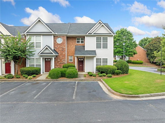Front view of a two-story townhouse with a brick and siding exterior.