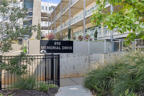 Front view of a multi-story building with balconies and large windows.