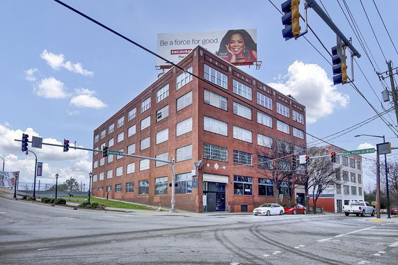 Front view of a multi-story brick building at an intersection.