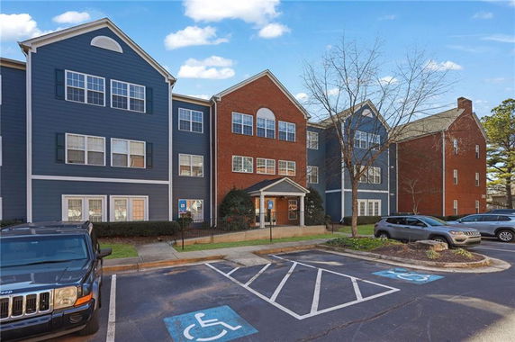 Front view of a multi-story residential building with brick and blue paneling.