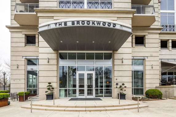 Front view of a building entrance with glass doors and a sign reading 'The Brookwood'.
