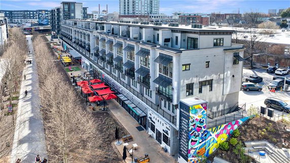 Front view of a multi-story building with a colorful mural on the side.