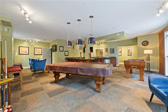 Indoor recreation area with a pool table, foosball table, and seating area.