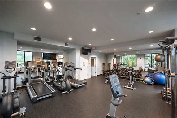 Indoor gym area with exercise equipment and mirrors.