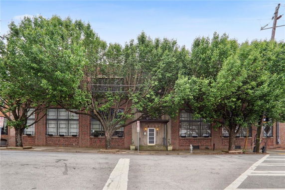 Front view of a brick building with large windows.