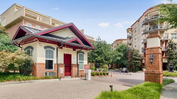 Front view of a residential complex with multi-story buildings and a small entrance pavilion.