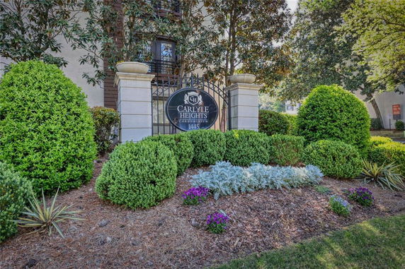 Front view of Carlyle Heights condominium with decorative shrubs and signage.