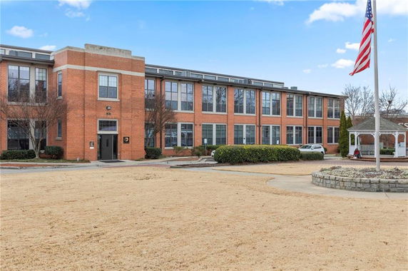 Front view of a multi-story brick building with large windows.