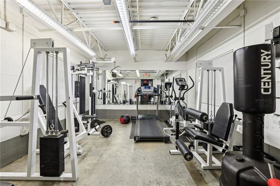 Indoor gym area with various exercise equipment including a treadmill, weights, and a punching bag.