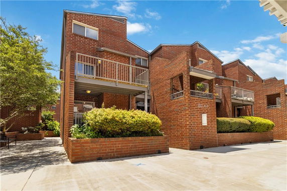 Front view of multi-story brick residential buildings with balconies.