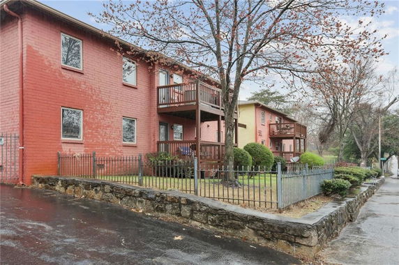 Front view of a two-story apartment building with a fenced yard.
