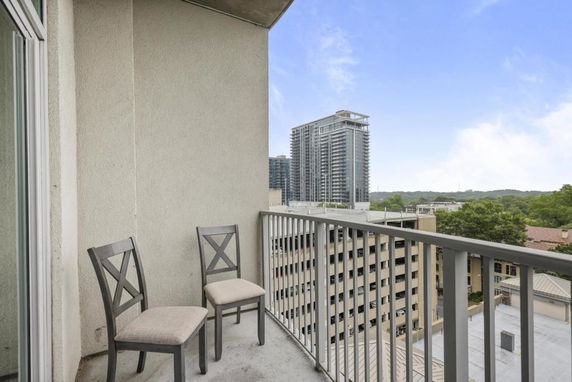 High-rise balcony with view of surrounding buildings and greenery.