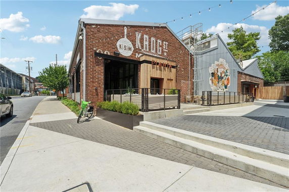 Front view of a brick building with large signage and outdoor seating area.