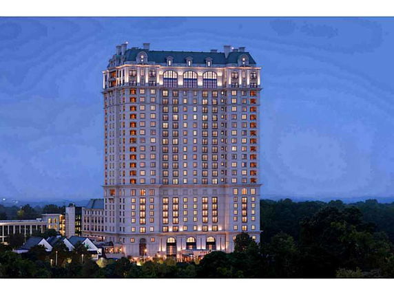 Front view of a multi-story building with numerous windows and decorative roof.