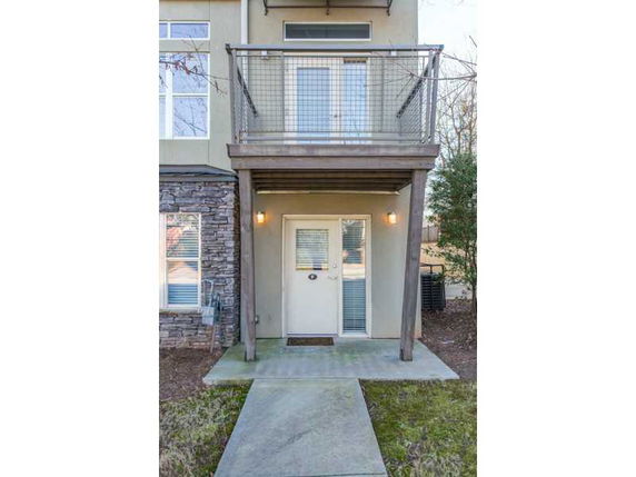 Front view of a house with a small balcony and front door lighting.