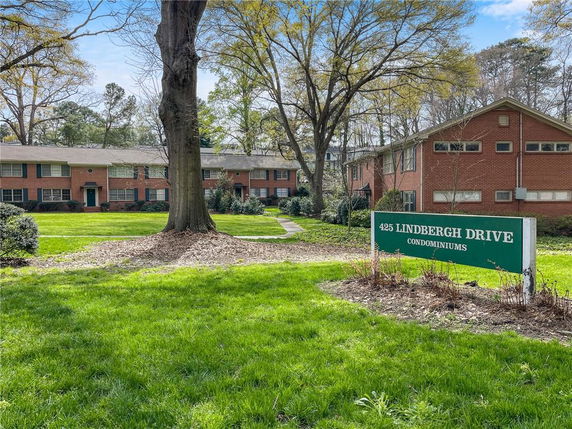 Front view of a condominium complex with multiple buildings surrounded by greenery.